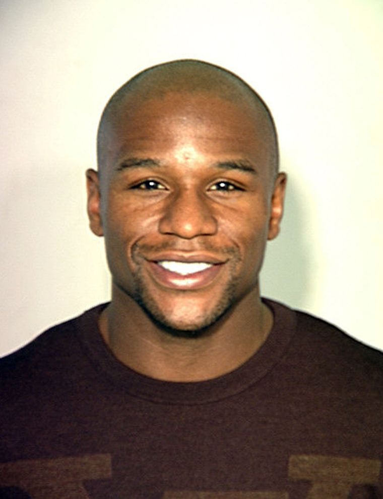 Floyd Mayweather smiles in his police mugshot after being arrested in Las Vegas over an outstanding warrant for an alleged assault in 2010.
