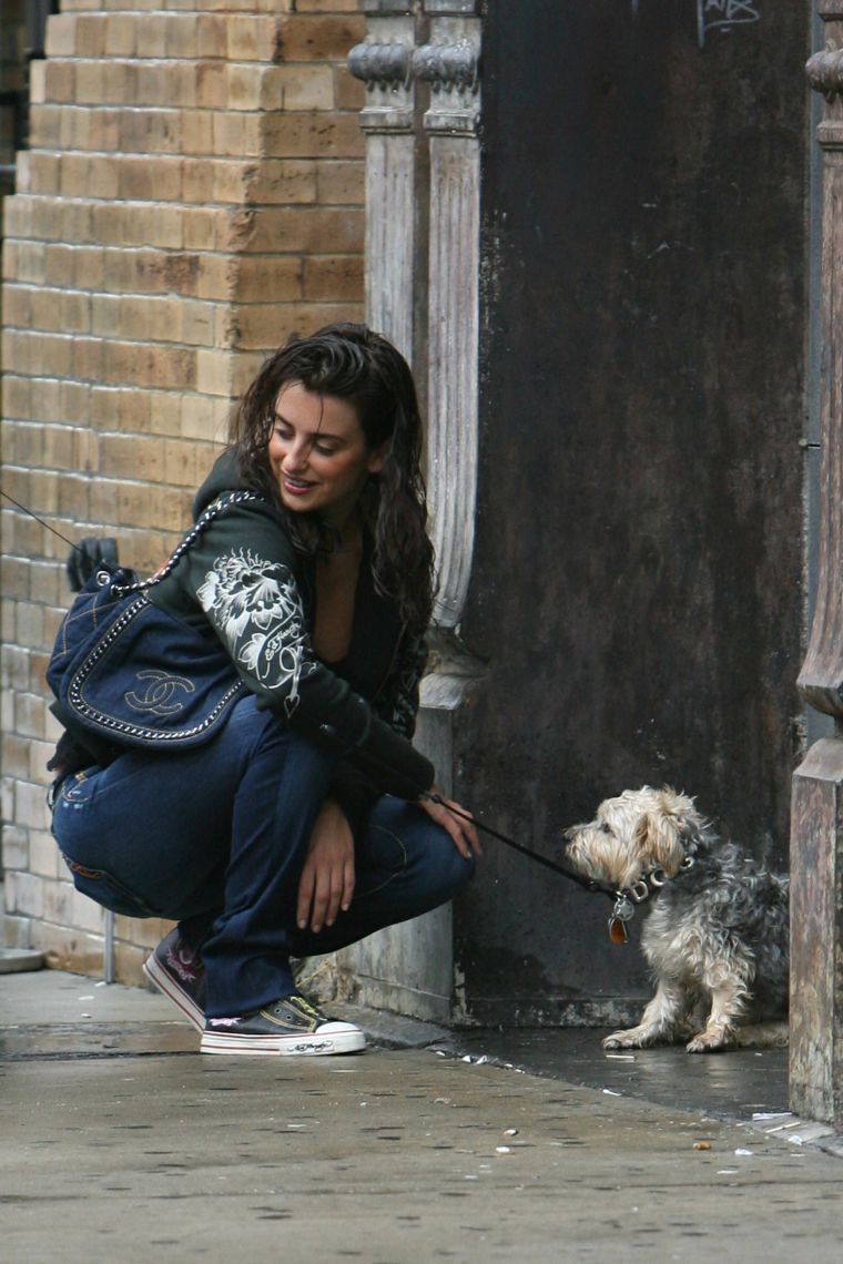 Penelope Cruz playing with her dog in the rain.