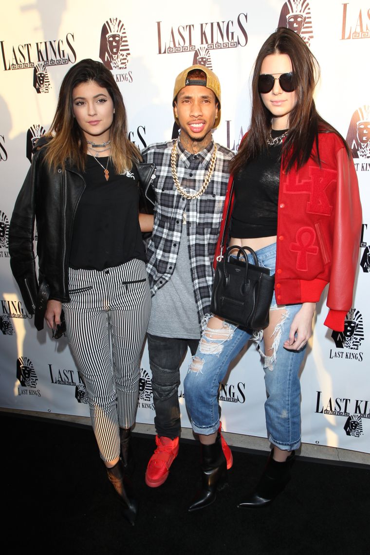 Tyga cozies up to the Jenner sisters.