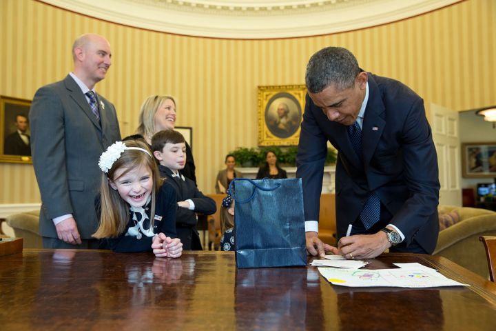 According to her big grin, watching the president sign an executive order is a lot of fun.