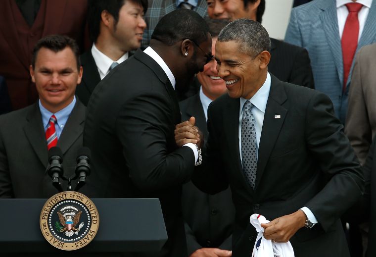 President Obama daps a White House visitor up with the mean “We Made It” mug.