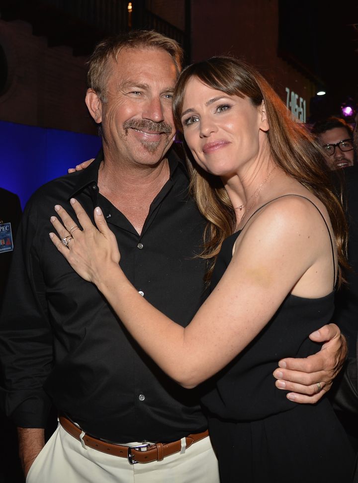 Kevin Costner and actress Jennifer Garner share a friendly hug at the after party for “Draft Day.”