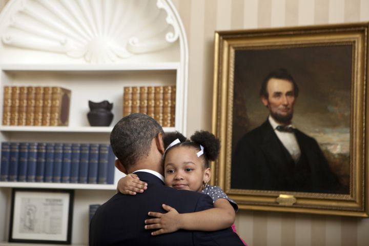 President Obama gets the biggest of hugs from an adorable girl with adorable pig tails in the White House.