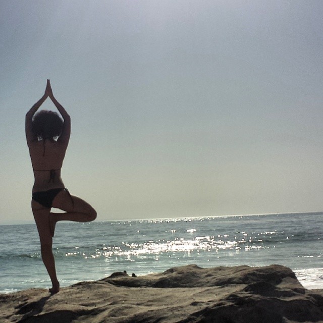 Natalie Emmanuel doing some beach yoga.
