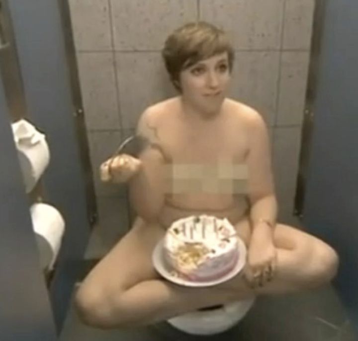 Dunham enjoys cake in a stall while rocking her birthday suit.