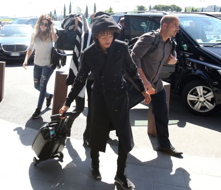 Jaden Smith helps the girls with their luggage as they leave Italy.