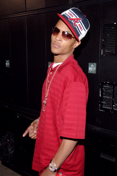 T.I. poses for a picture in his sideways fitted.