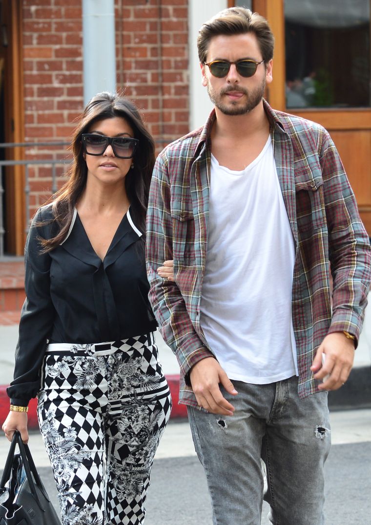 Kourtney wraps her arm around her man.