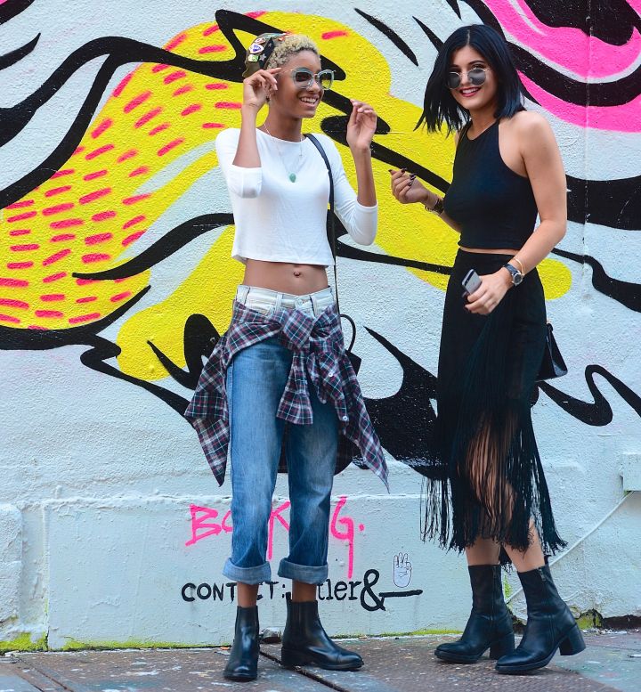 Kylie and Willow laugh in front of some street art