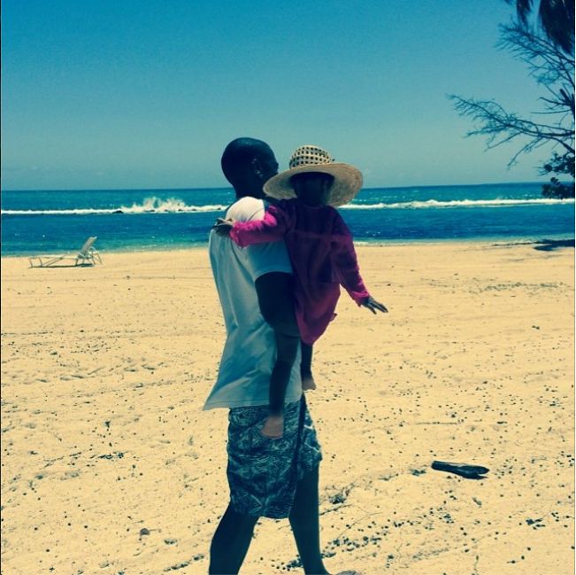 Blue rocked her sun hat while taking a stroll in the sand with her dad.
