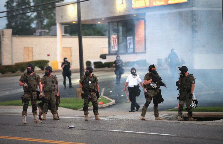 Officers stand guard after firing tear gas into the crowd.