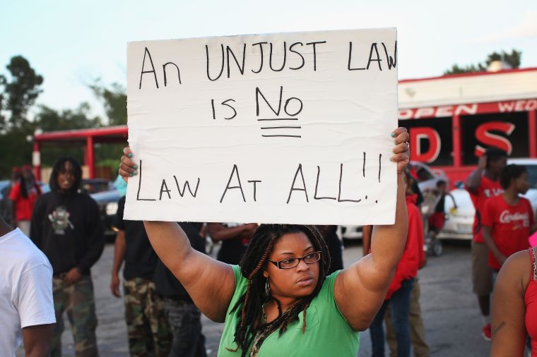 A woman holds a powerful sign.