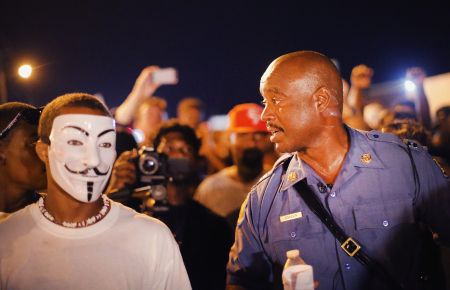 Capt. Ronald Johnson of the Missouri State Highway Patrol, who was appointed by the governor to take control of security operations in the city of Ferguson, walks with protesters.