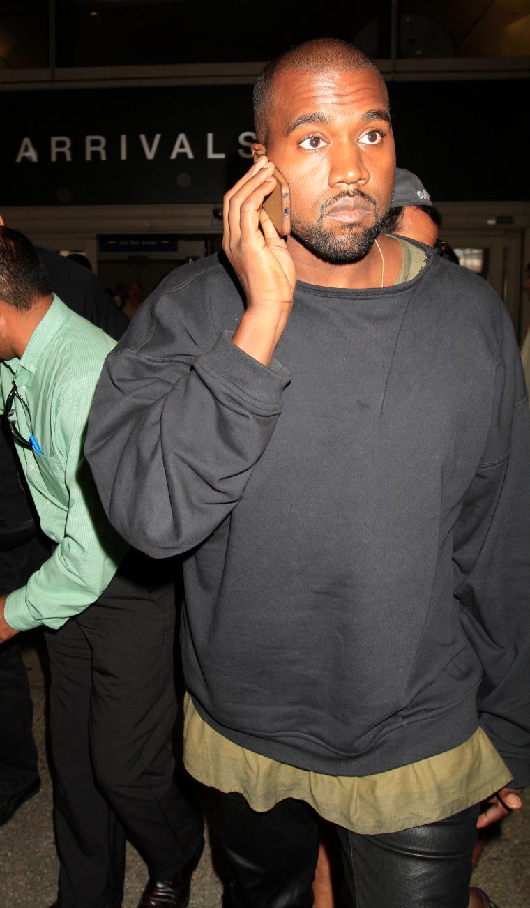 Kanye talks on the phone while arriving in LAX