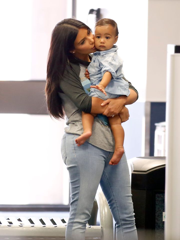 Mom Kim gave North a smooch on the cheek while the little cutie rocked her denim top at the airport.