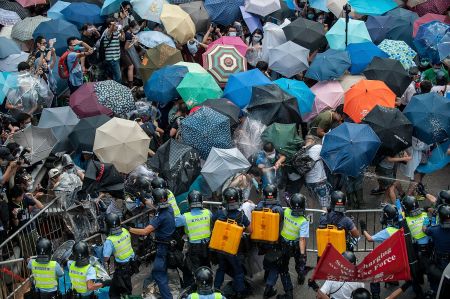 Demonstrators use umbrellas to protect themselves from tear gas during protests.