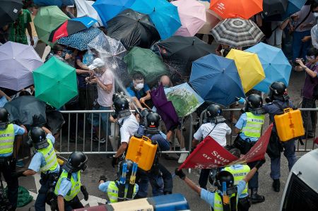 Protestors use umbrellas to shield them from tear gas.