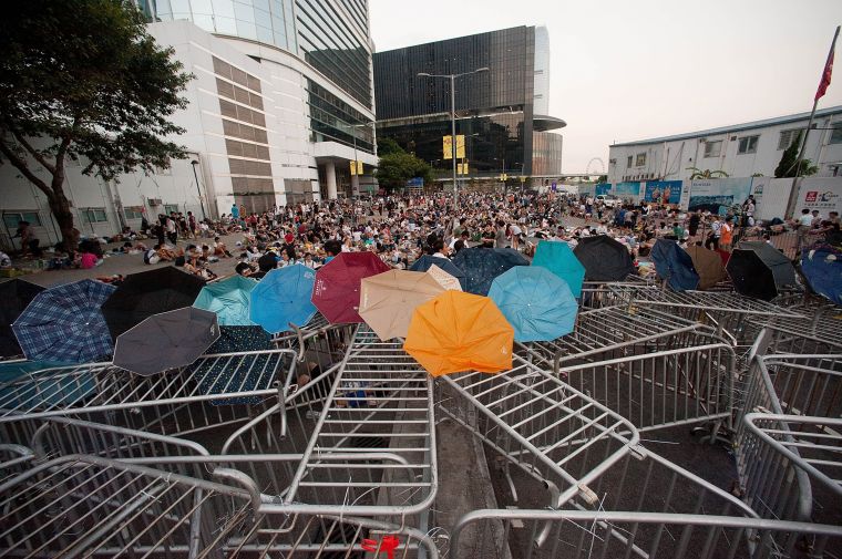 Protestors use umbrellas to shield them from tear gas.