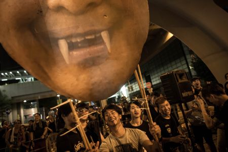 Protesters carry a cardboard poster of C.Y.Leung, Hong Kong’s Chief Executive, near the Hong Kong Government Complex.