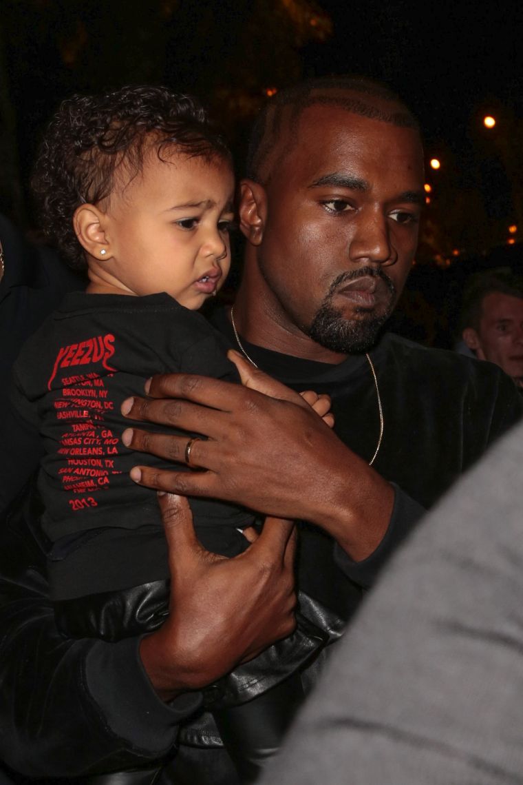 Kim Kardashian, Kanye, & North West attend the Balenciaga show during Paris Fashion Week.