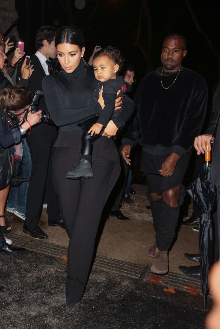 Kim Kardashian, Kanye, & North West attend the Balenciaga show during Paris Fashion Week.