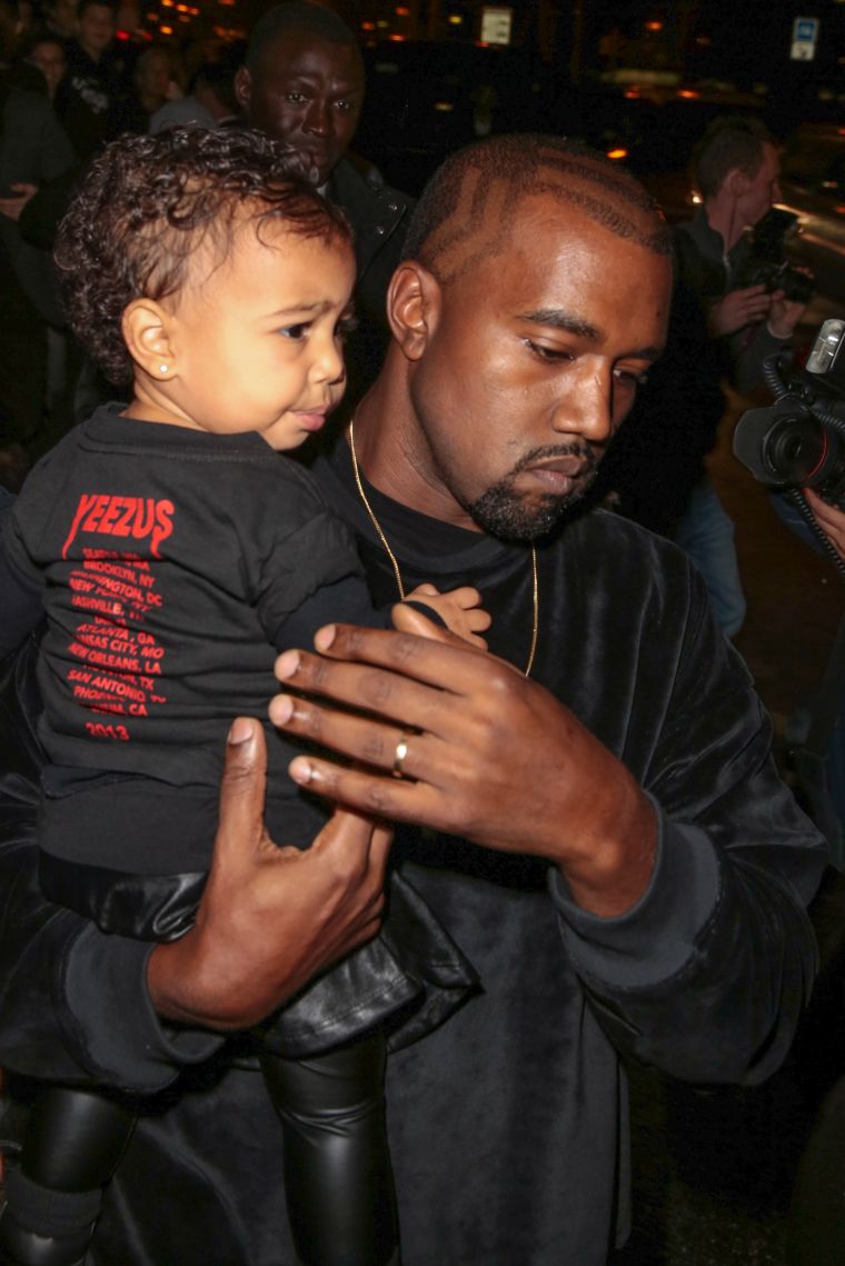 Kim Kardashian, Kanye, & North West attend the Balenciaga show during Paris Fashion Week.