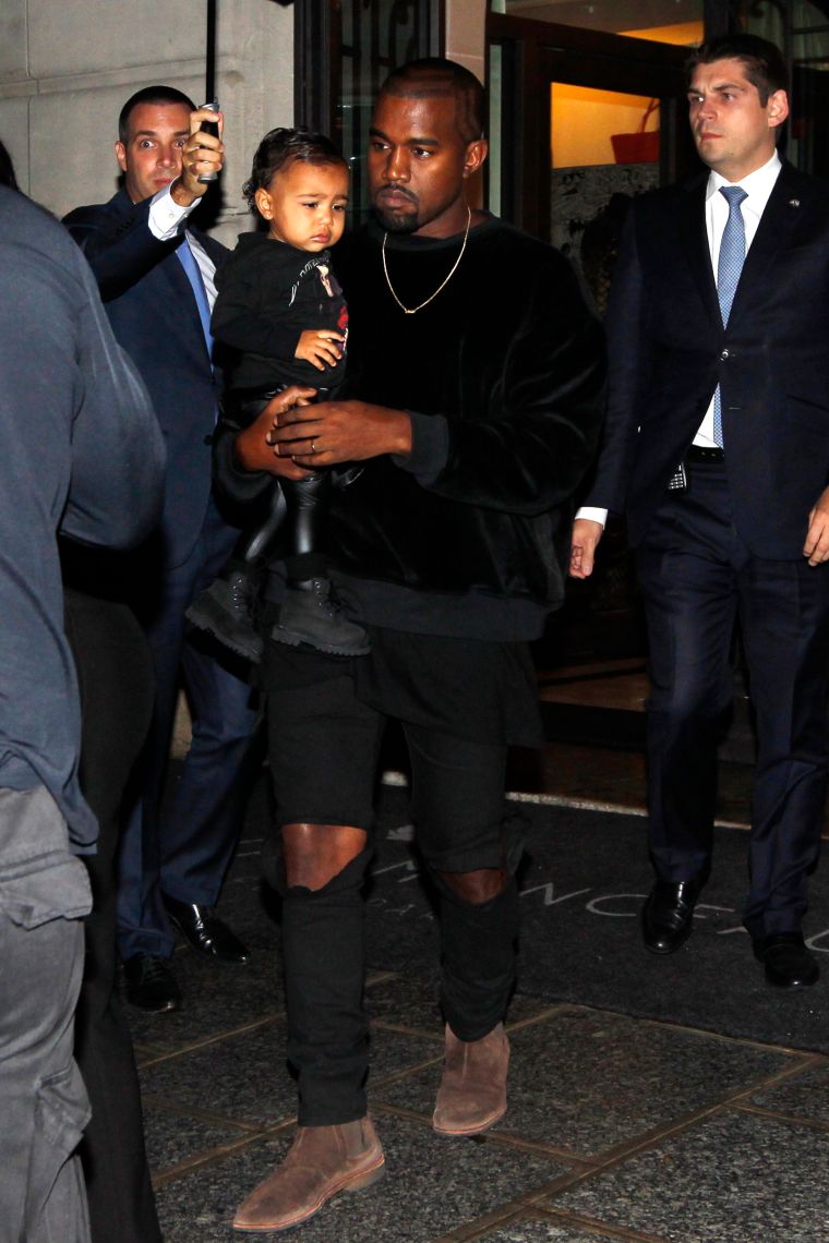 Kim Kardashian, Kanye, & North West attend the Balenciaga show during Paris Fashion Week.