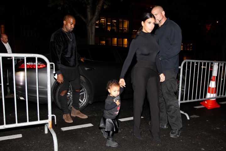 Kim Kardashian, Kanye, & North West attend the Balenciaga show during Paris Fashion Week.