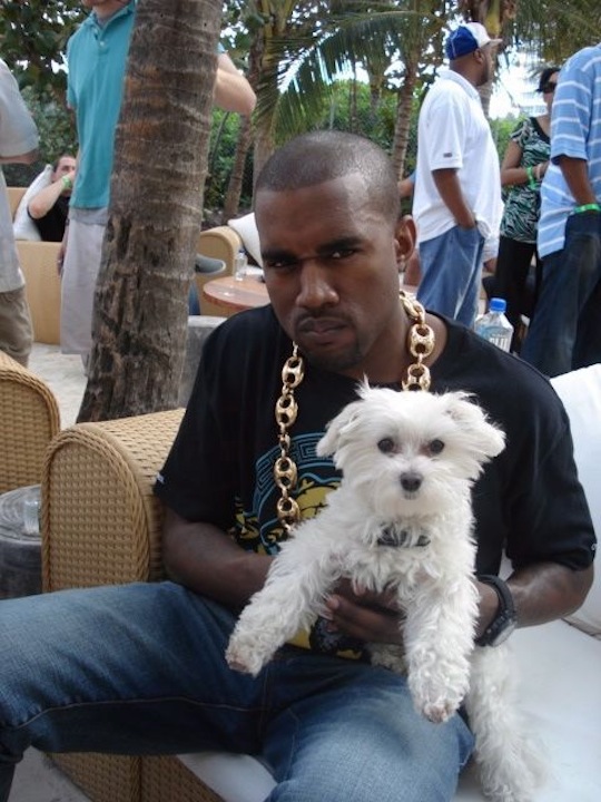 Kanye West playing with little fluffy doggy.