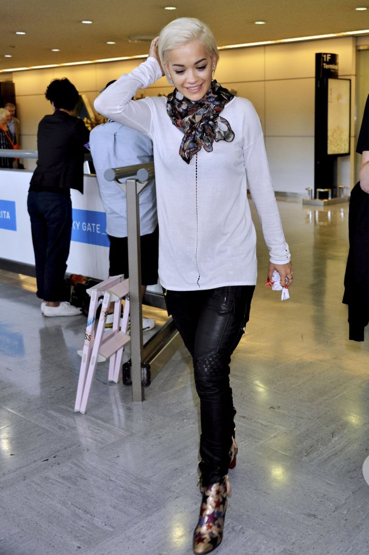 Rita Ora sports her signature red lip and sexy leather pants as she makes her way through Narita Airport.