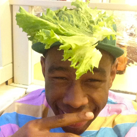 This is Tyler, The Creator with a piece of lettuce on his head.