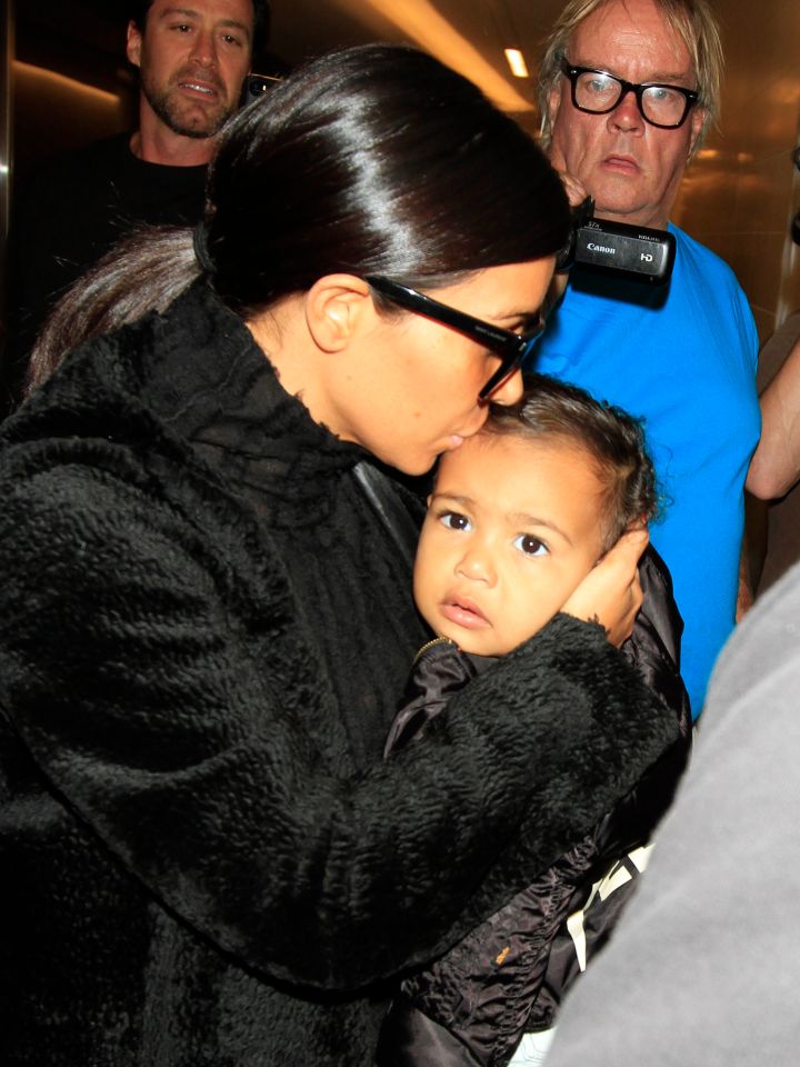 She got another forehead kiss from mommy at LAX while wearing her Yeezus tour jacket.