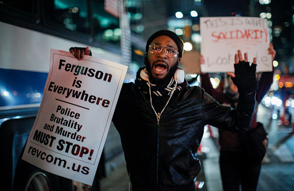 A man holding a sign takes part in protest after a grand jury decided not to indict New York Police Officer Daniel Pantaleo in the death of Eric Garner.