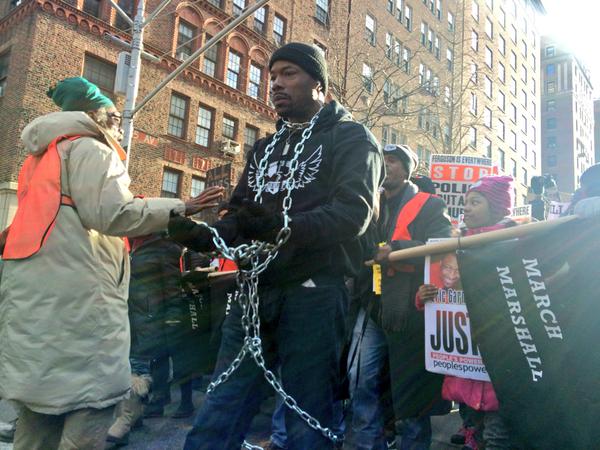 A protestor marches while in chains.