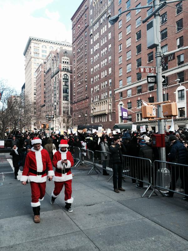 Santa Con participants face the interrupting protests happening through the streets.