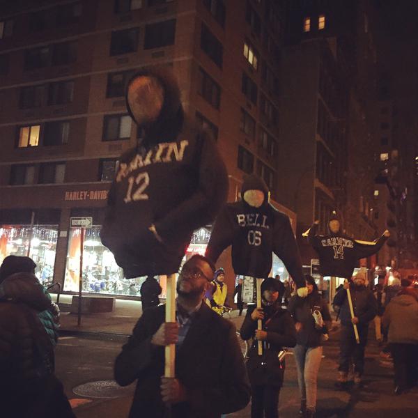 Picketed versions of the victims of police brutality are held up during the march.