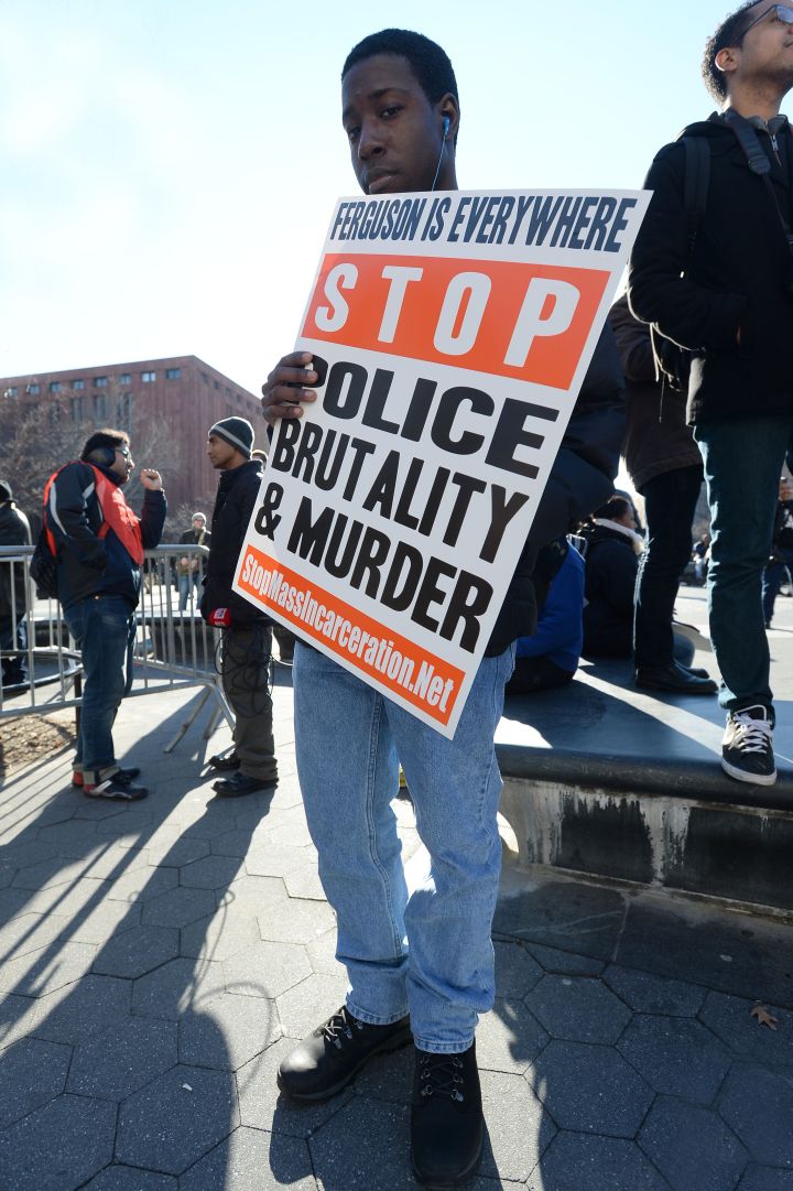 A protester holds up a sign to stop police brutality.