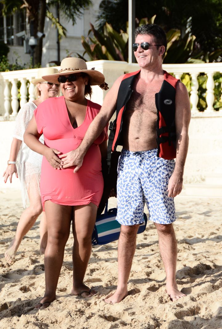 That baby is going to be the next Rihanna! Simon Cowell touches a pregnant woman’s belly while on vacation in Barbados.