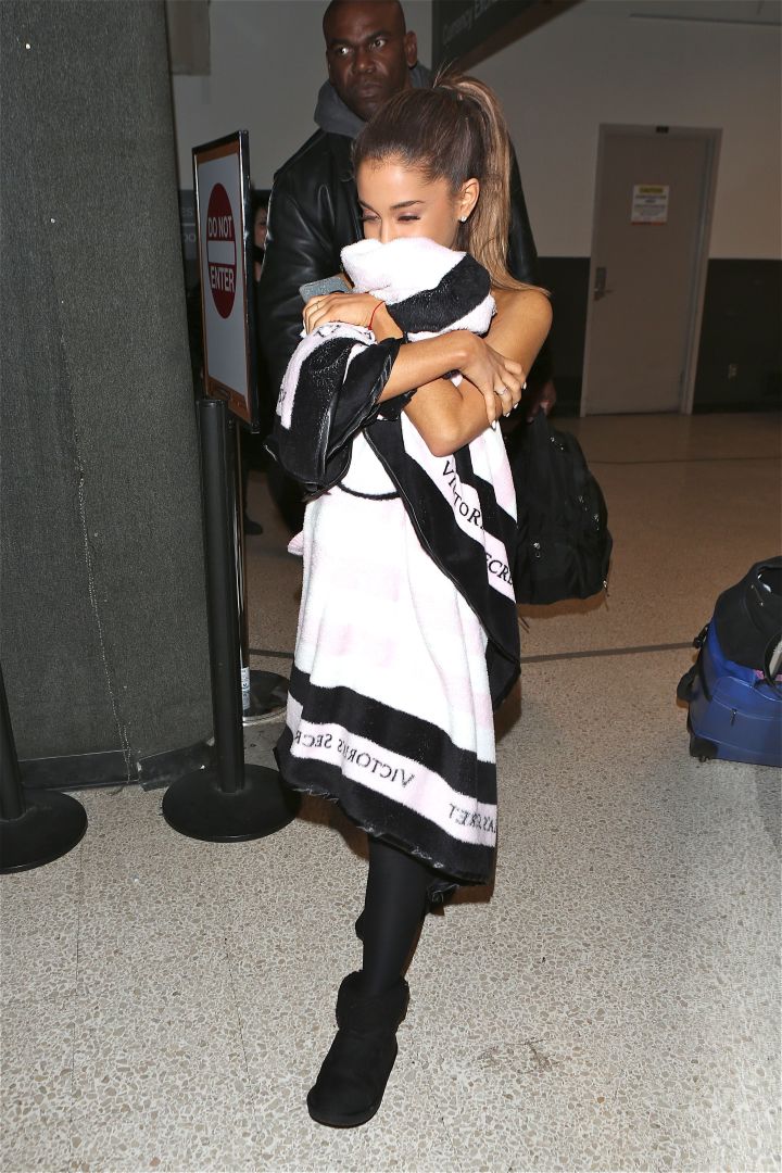 No pictures please! Ariana Grande covers up as she heads through LAX.