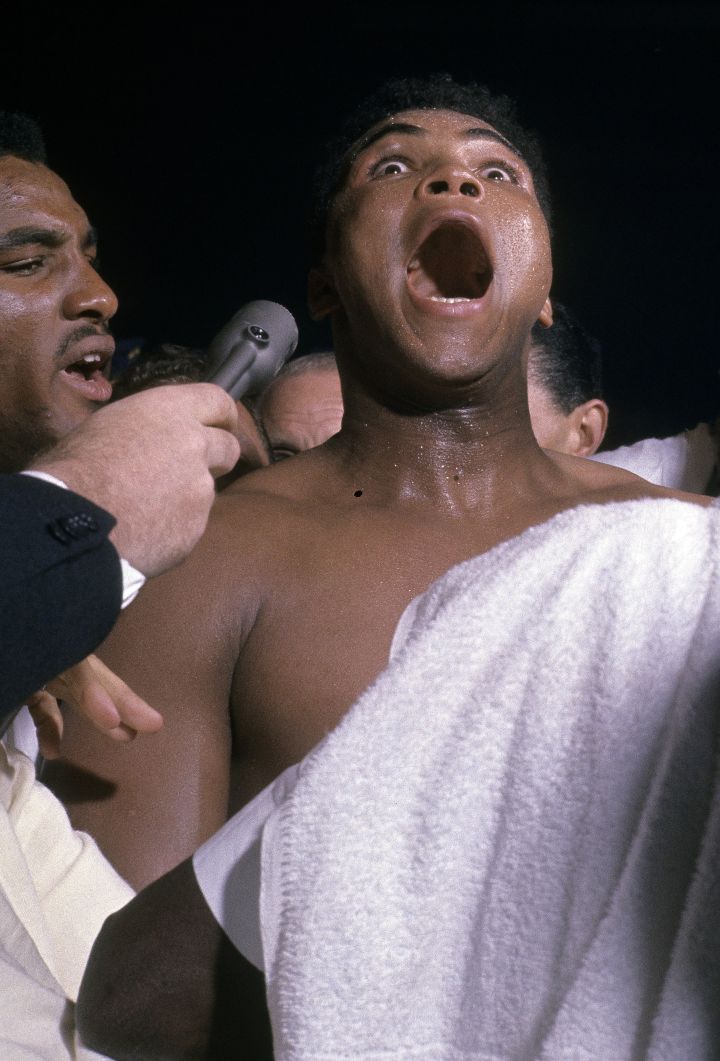 FEBRUARY 25, 1964: Cassius Clay (aka Muhammad Ali) talks into a reporter’s mic after defeating Sonny Liston, not pictured in a World Heavyweight Title fight February 25, 1964 at Convention Hall in Miami, Florida.
