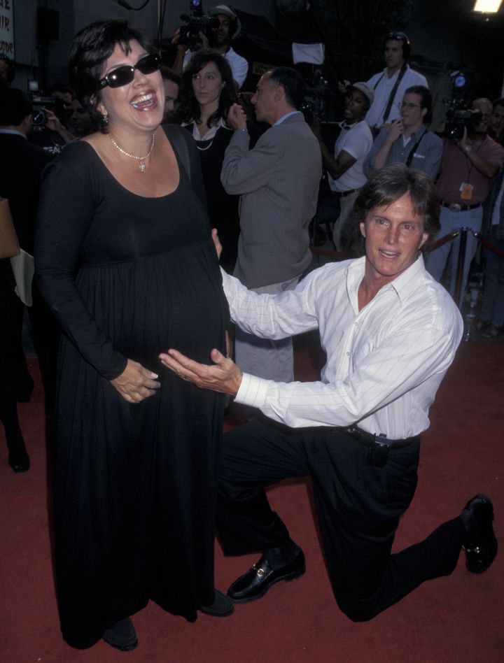 Bruce Jenner shows a pregnant Kris Jenner love on the red carpet.