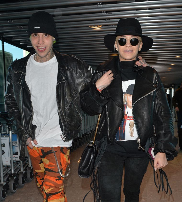 Rita Ora and her beau Ricky Hilfiger are punk rock in matching leather jackets at Heathrow Airport.