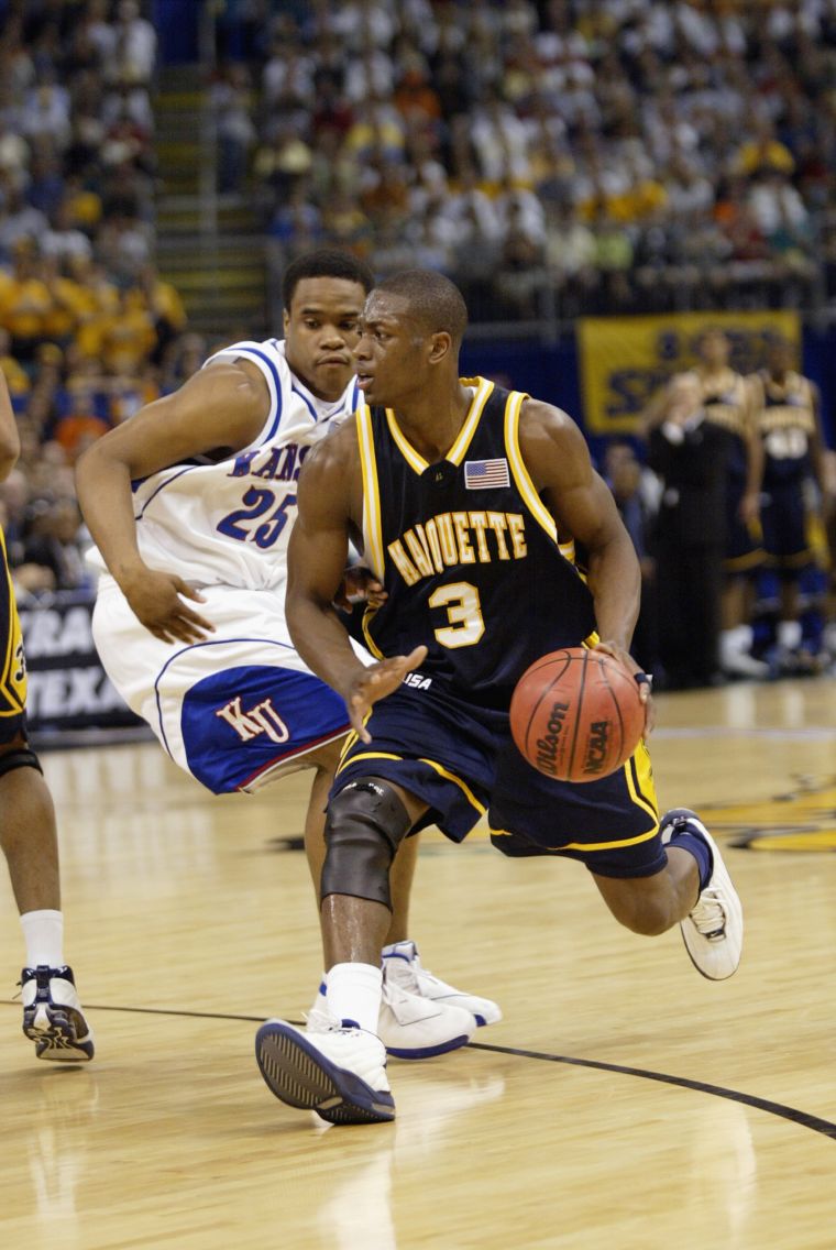 Flash drives past Kansas Jayhawks player during the semifinal of the NCAA Tournament, 2003.