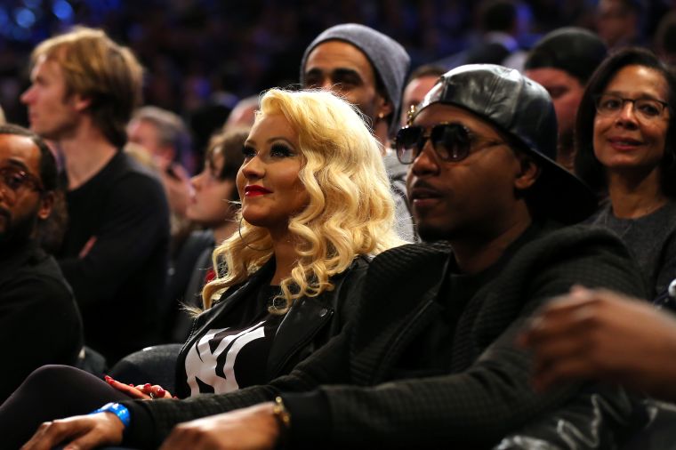 Christina Aguilera and Nas sit on the sidelines.