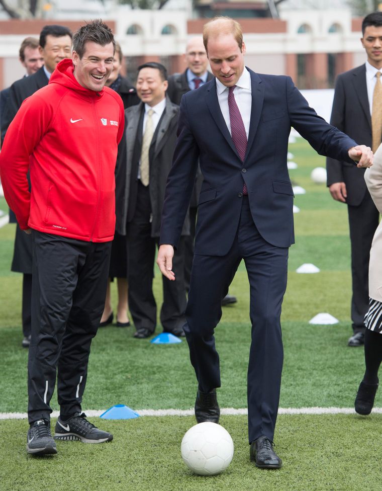 Prince William takes a stab at some footy while attending a Premier Skills coaching session at a high school in Shanghai.