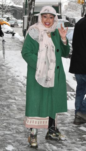Actress/singer Raven Symone, wearing a pink scarf wrapped around her head, a green coat and Dr. Martens with the tag still on them, leaves 'The View' in the snowy NYC weather