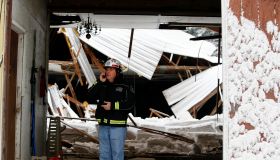 An official stands in front of a partial roof collapse