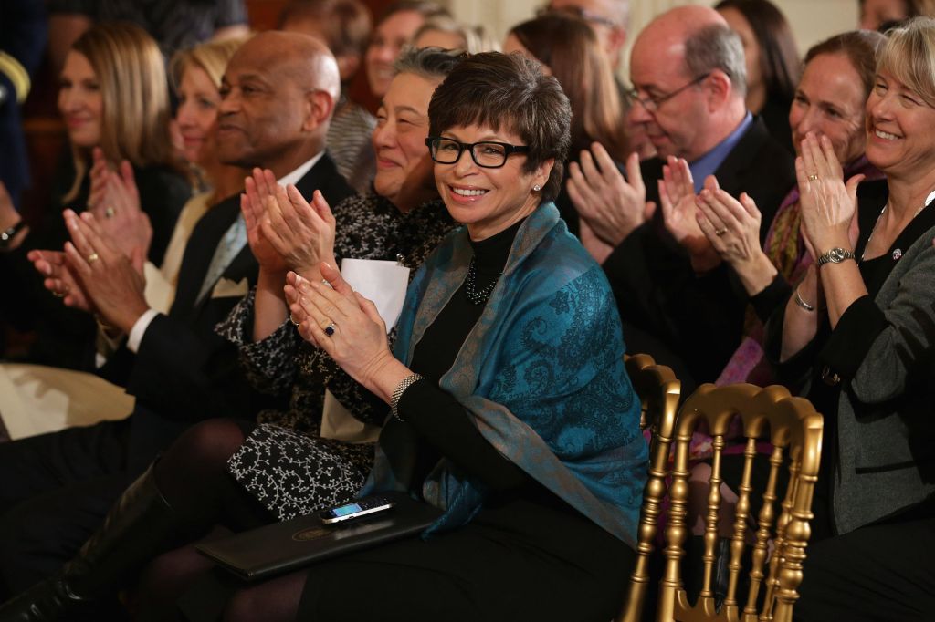 White House Senior Advisor Valerie Jarrett (C) applauds as U.S. first lady Michelle Obama and President Barack Obama
