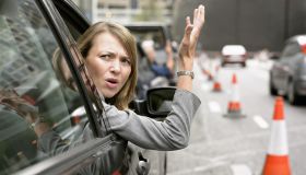 Anoyed Woman Looking Out Her Car Window Gesturing
