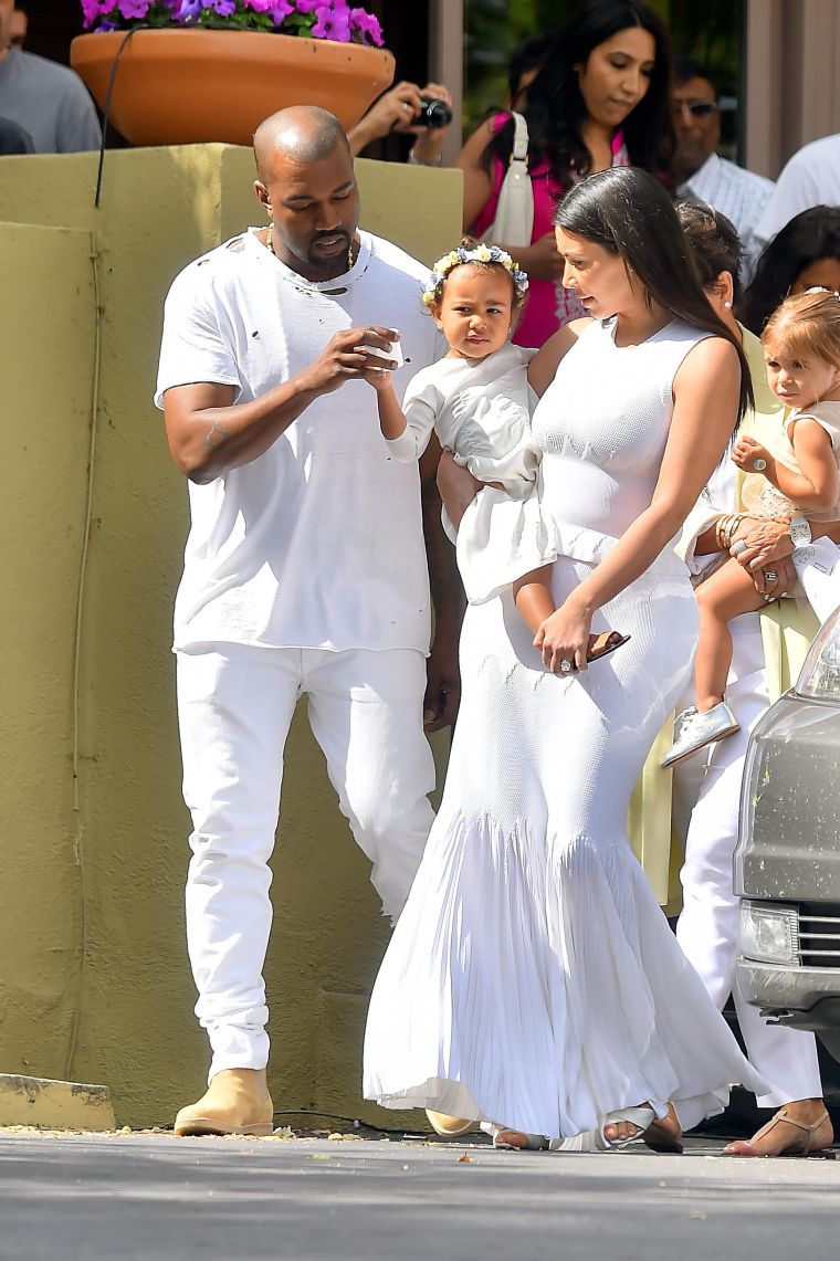 Meet the Wests. Kanye tends to his daughter North as Kim holds her before church.